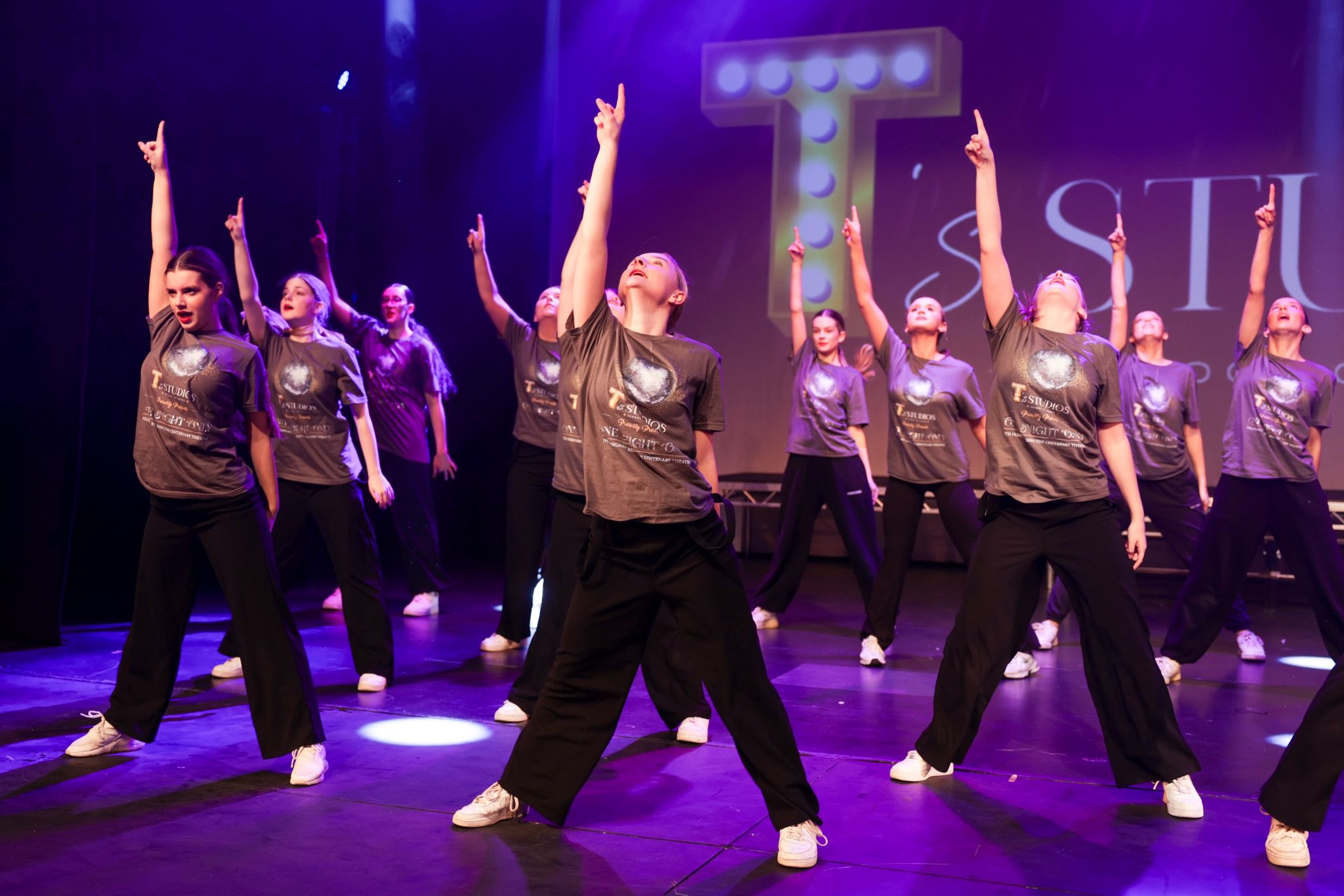 T's Studios group routine in branded tops