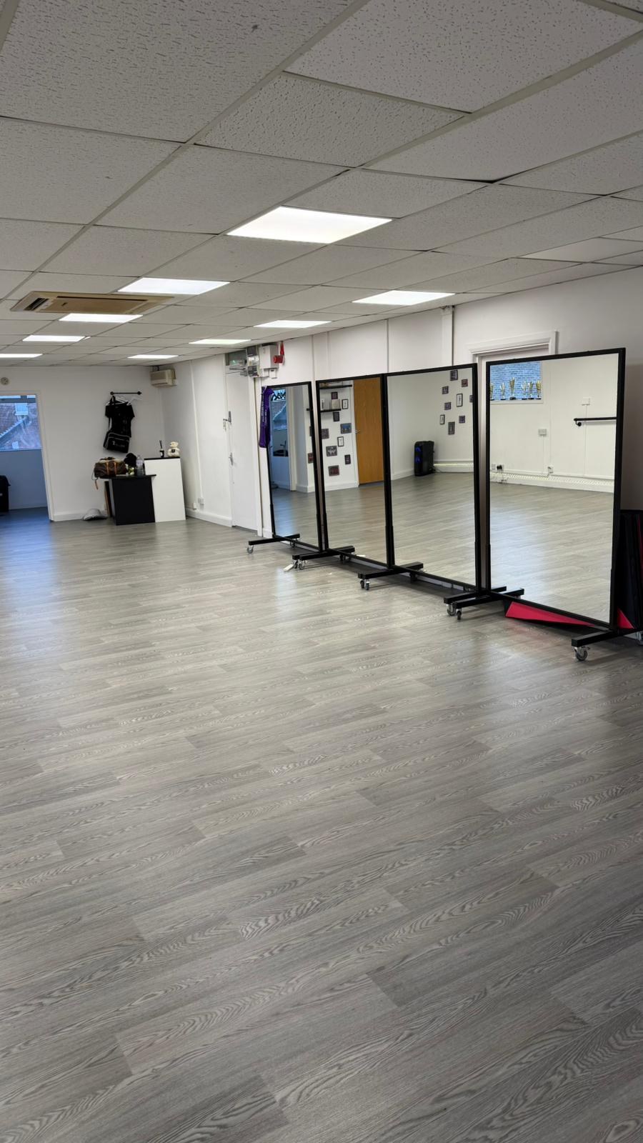 Spacious studio floor with mirrors and doorway